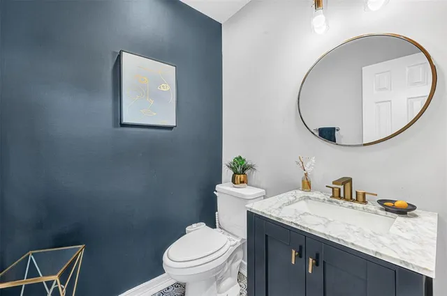 a bathroom with a granite countertop toilet sink and mirror