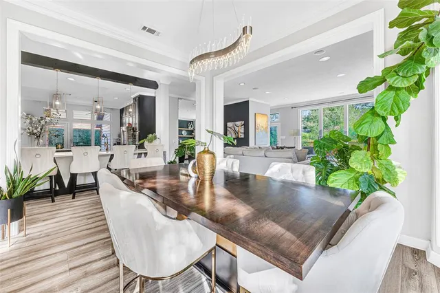 a dining room with furniture a potted plant and wooden floor