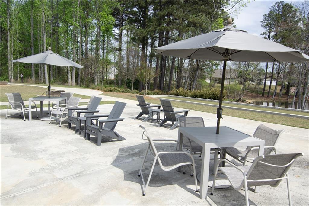 2472 Knob Crk Road Snellville, GA 30078 - Photo 29 of 30 a view of a patio with a dining table and chairs under an umbrella
