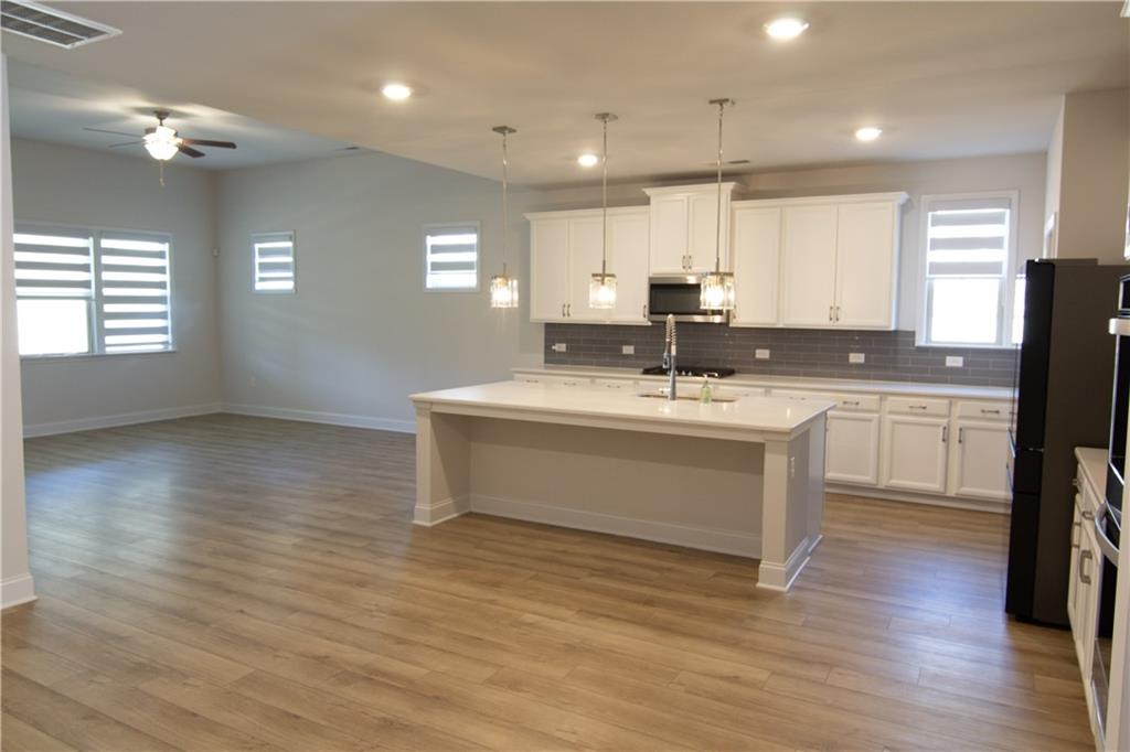 2472 Knob Crk Road Snellville, GA 30078 - Photo 3 of 30 a kitchen with a sink cabinets stainless steel appliances and wooden floor