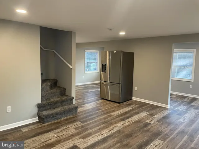 a view of a livingroom with wooden floor and staircase