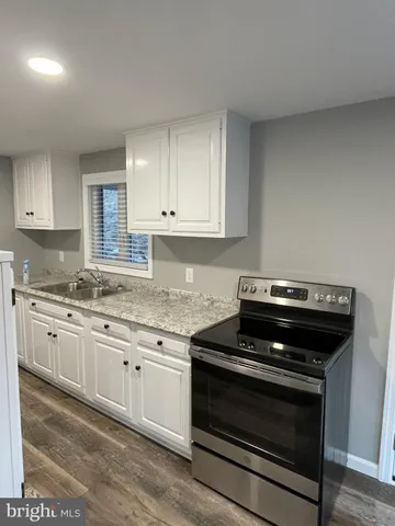 a kitchen with granite countertop a stove and a sink