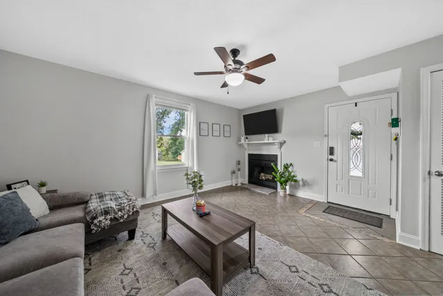 a living room with furniture a fireplace and a window