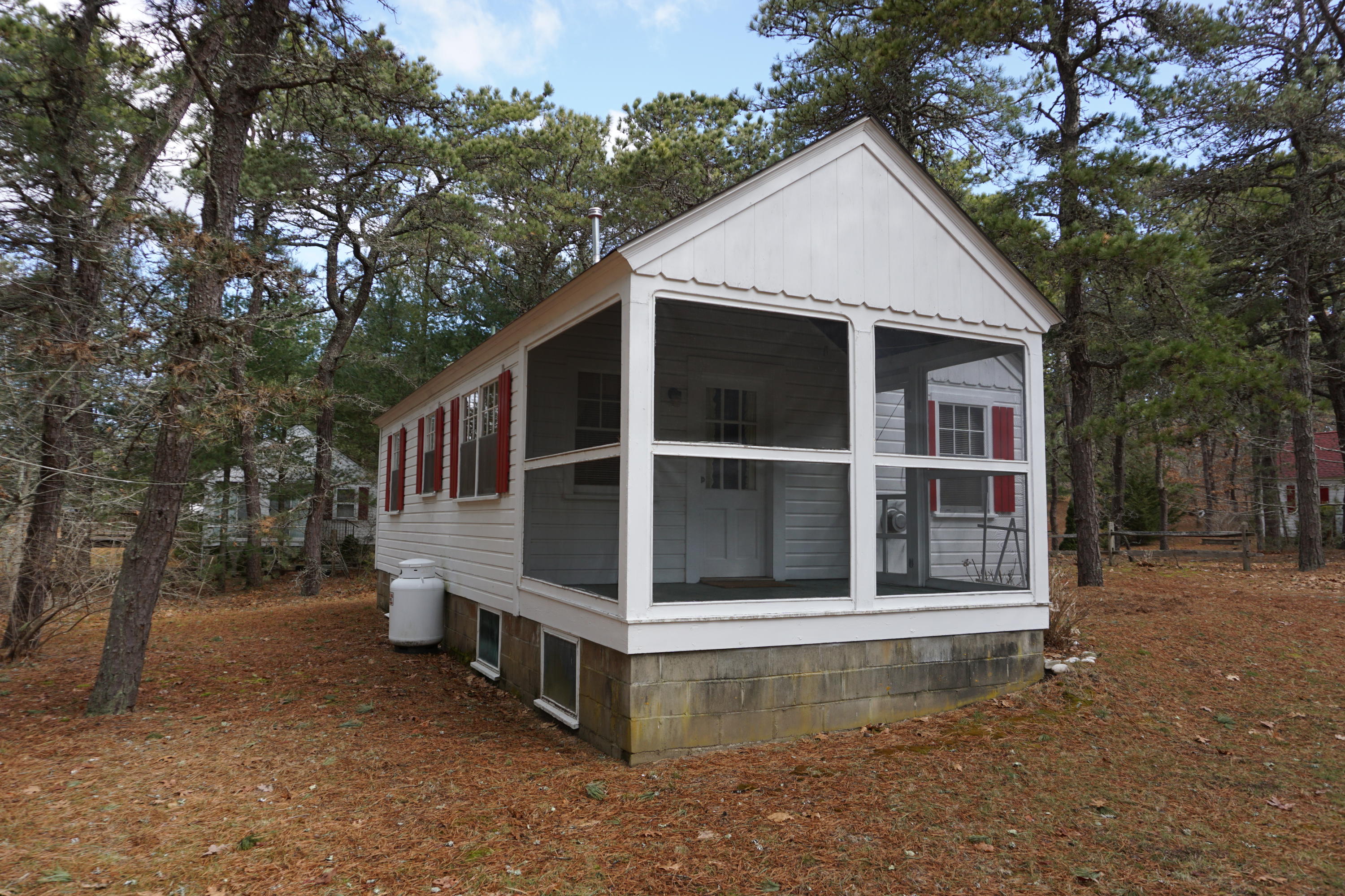 124 Castle Road, Unit 5 Truro, MA 02666 - Photo 4 of 22 a view of a wooden house with a large window and large tree