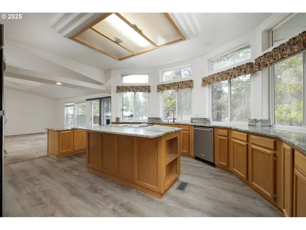 a kitchen with kitchen island granite countertop a stove and a sink