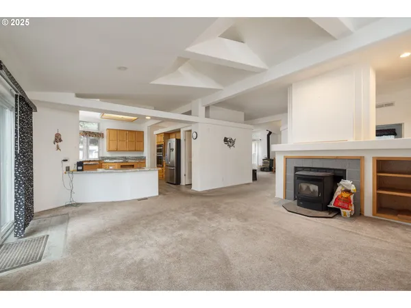a view of a livingroom and a kitchen with furniture and a fireplace