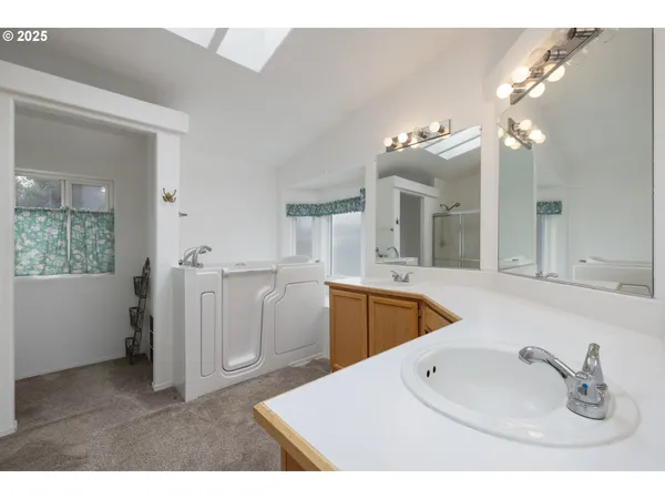 a en suite bathroom with a double vanity sink a mirror and a bathtub