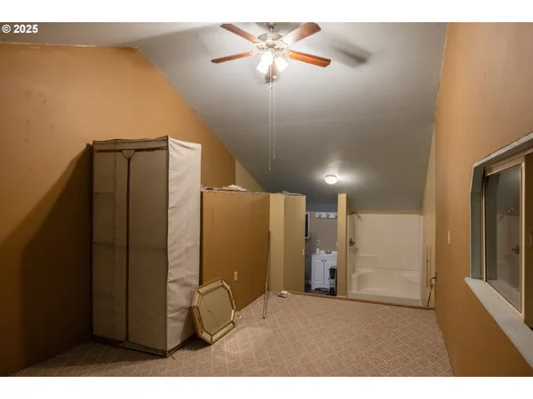a view of a refrigerator in kitchen and an empty room