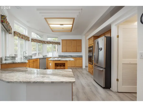 a kitchen with stainless steel appliances granite countertop a refrigerator a sink and a stove