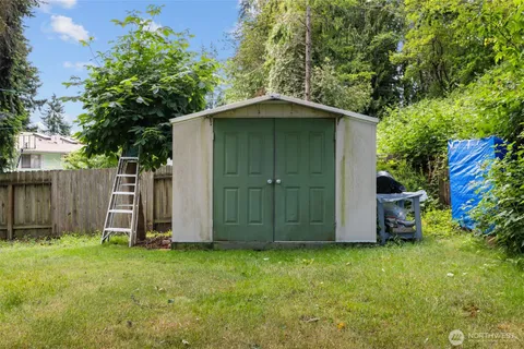 a backyard of a house with lots of plants and tree