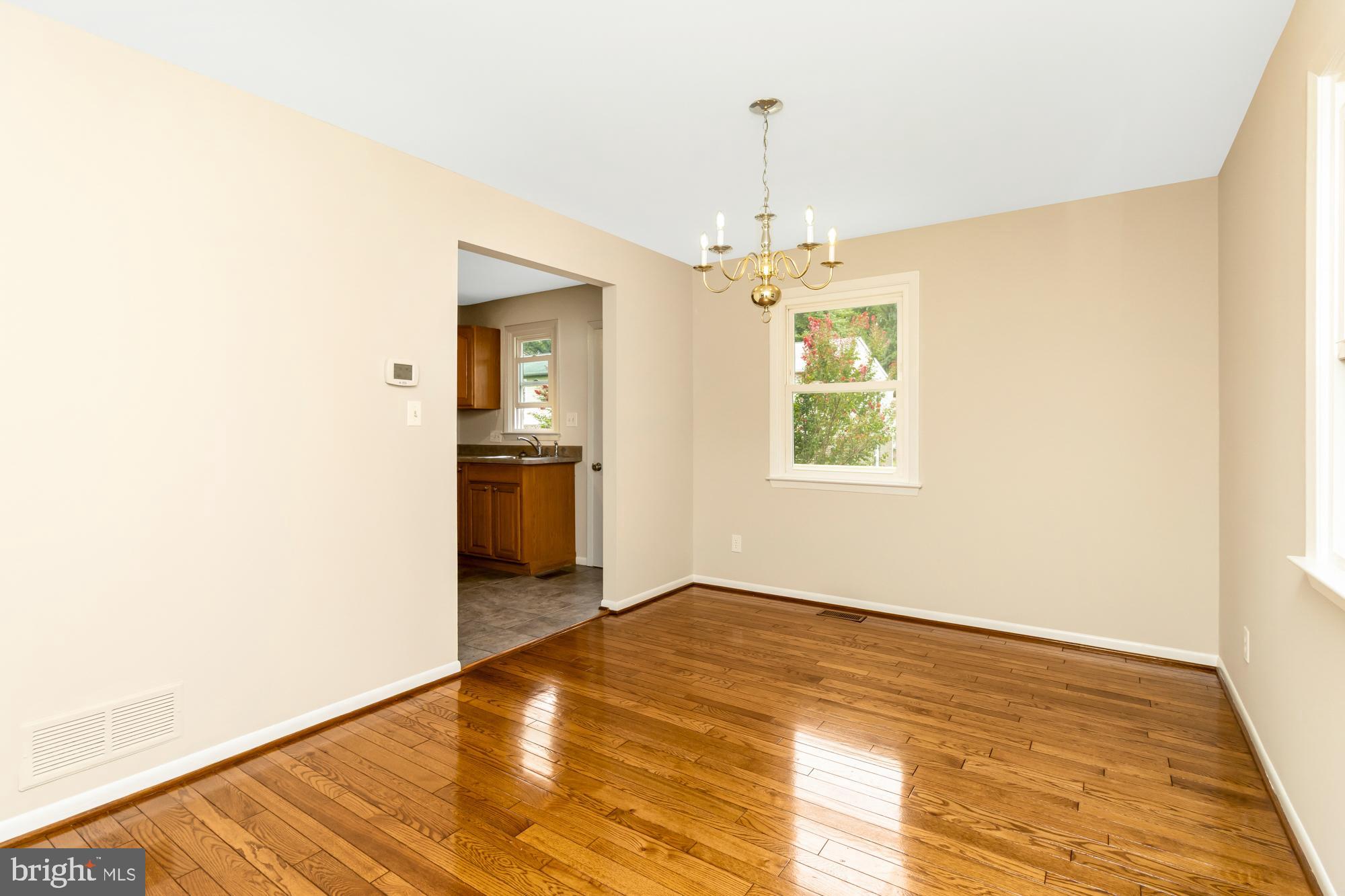 3640 Rockberry Road Baltimore, MD 21234 - Photo 7 of 37 a view of an empty room with window and wooden floor
