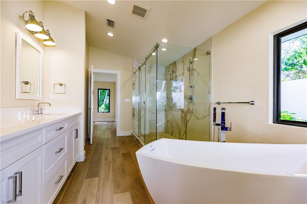 1300 Dolphin Road Naples, FL 34102 - Photo 10 of 22 a spacious bathroom with a granite countertop tub sink and mirror