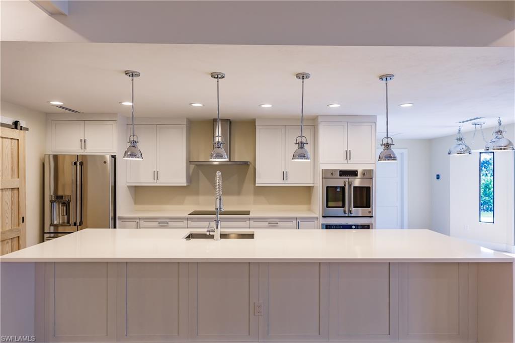 1300 Dolphin Road Naples, FL 34102 - Photo 3 of 22 a large kitchen with kitchen island a sink and stainless steel appliances