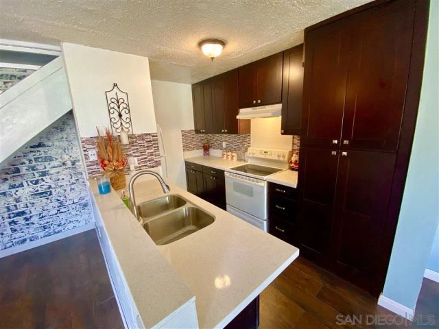 a kitchen with granite countertop a sink stainless steel appliances a counter top space and cabinets