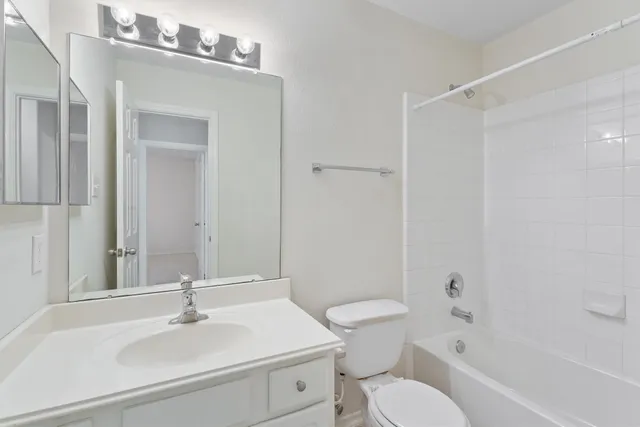 a bathroom with a sink toilet vanity and shower