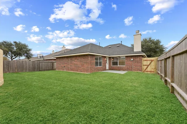 a view of a yard in front of a house with a large tree