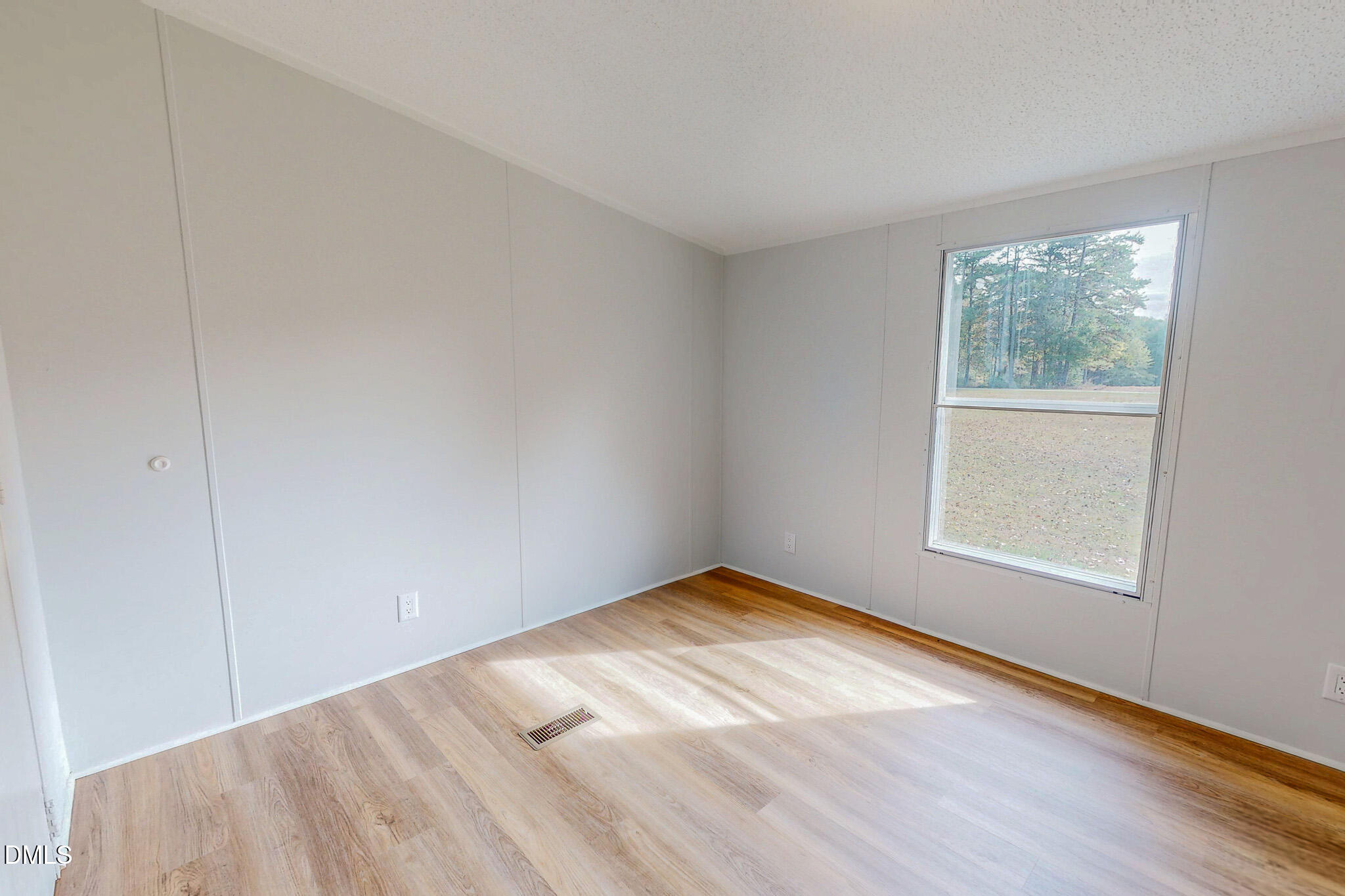 1469 Mollie Mooney Road Roxboro, NC 27574 - Photo 38 of 52 a view of an empty room with wooden floor and a window