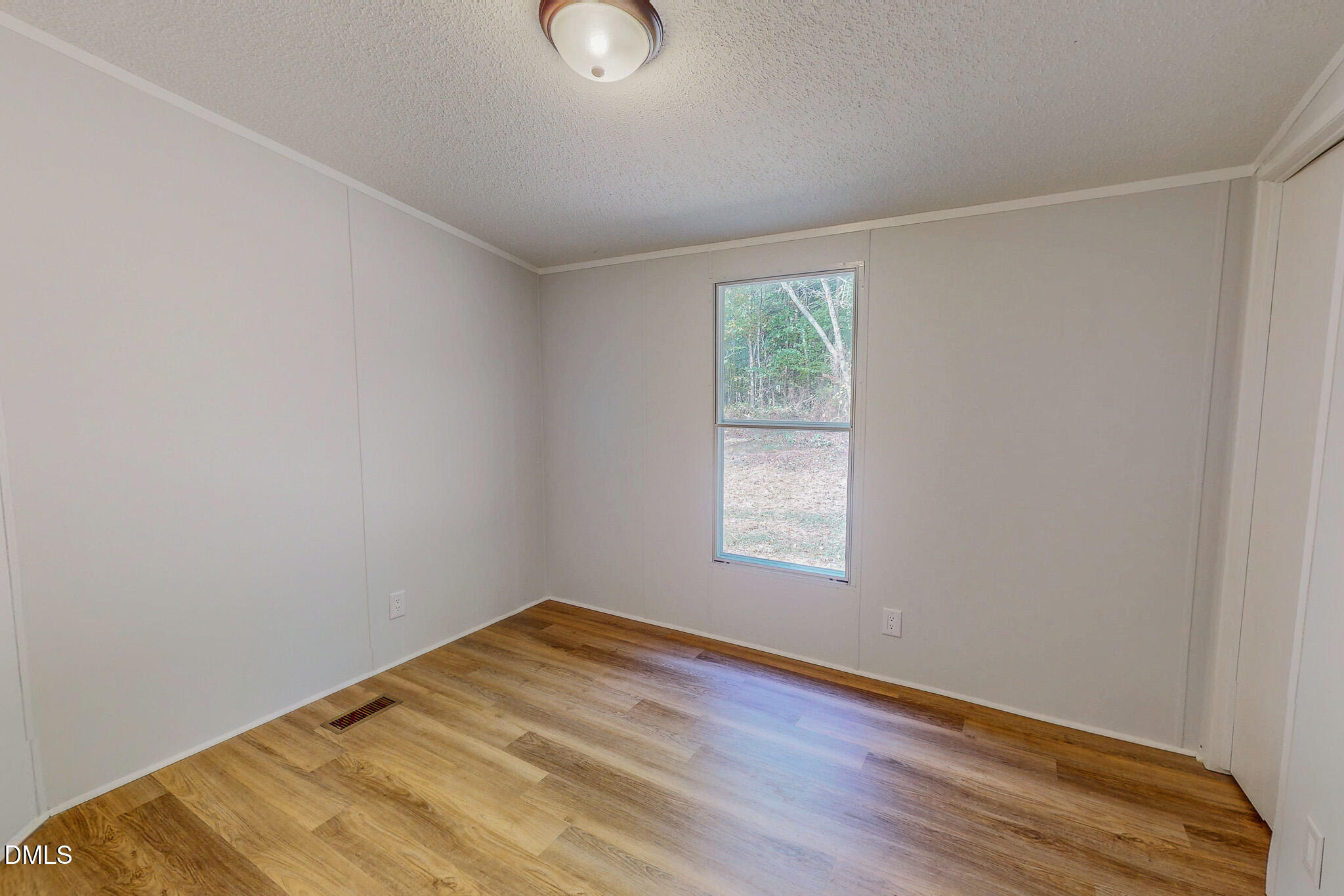 1469 Mollie Mooney Road Roxboro, NC 27574 - Photo 40 of 52 an empty room with wooden floor and windows