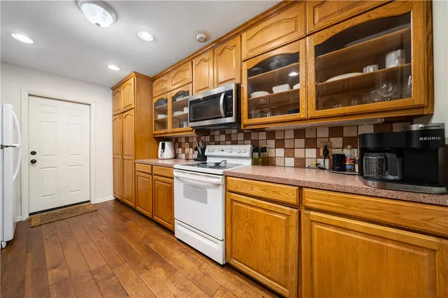 a kitchen with stainless steel appliances granite countertop a refrigerator and a stove top oven