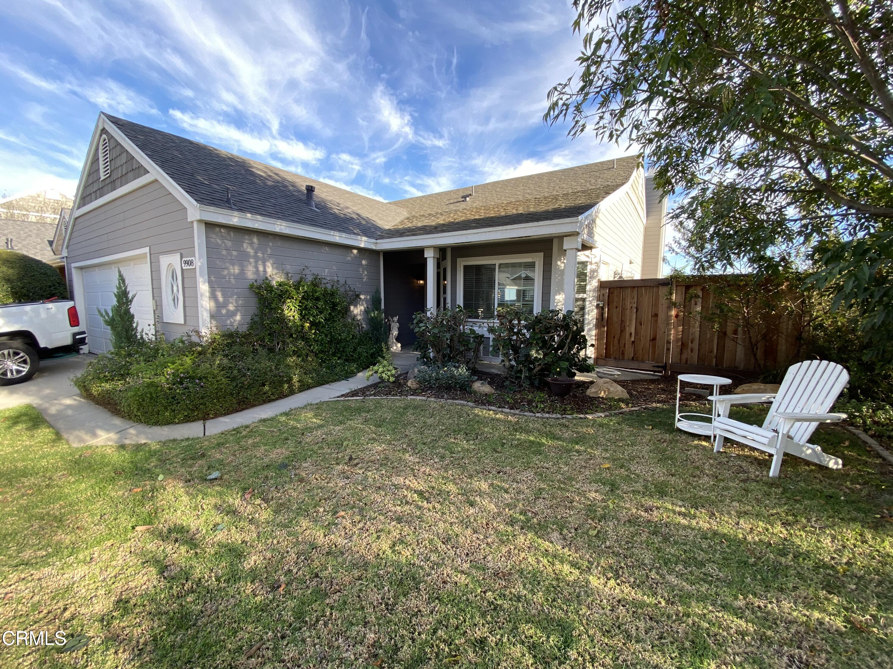 a view of a house with backyard and sitting area