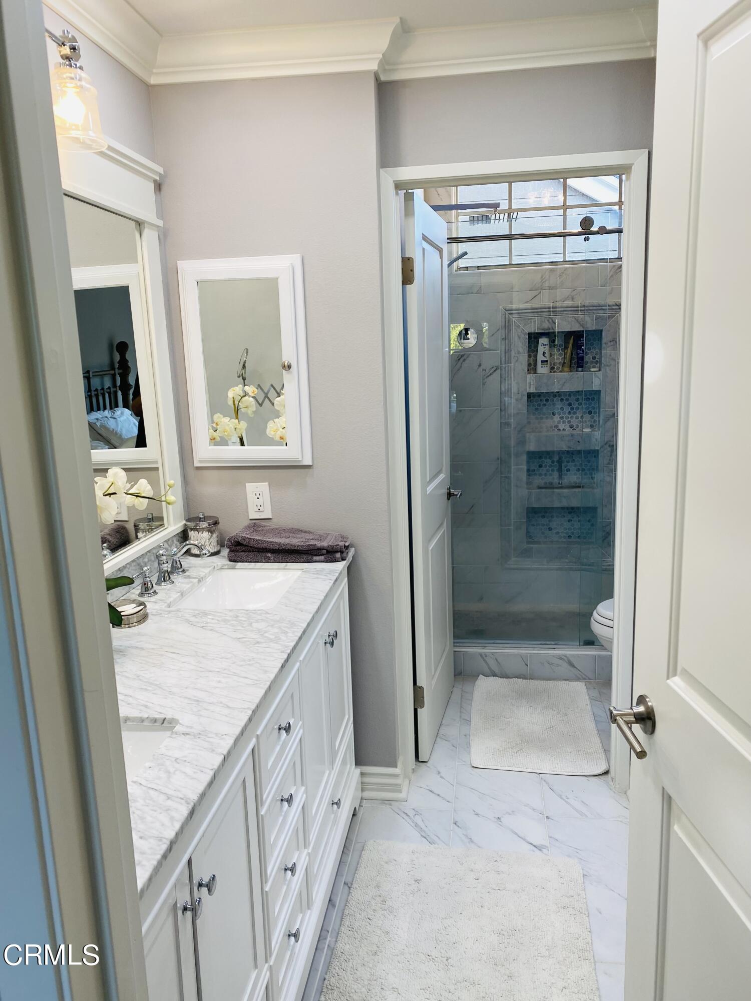 9908 Cheyenne Circle Ventura, CA 93004 - Photo 14 of 19 a bathroom with a granite countertop sink a mirror and shower