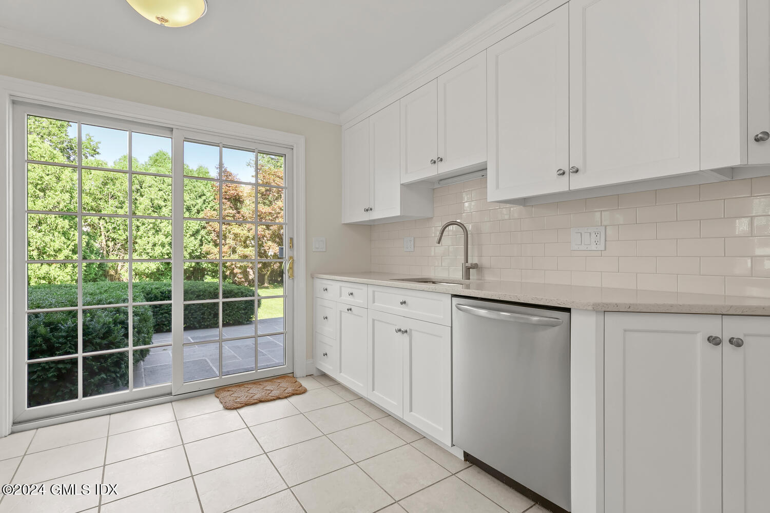 32 Rainbow Drive Riverside, CT 06878 - Photo 4 of 19 a kitchen with white cabinets a window and a sink