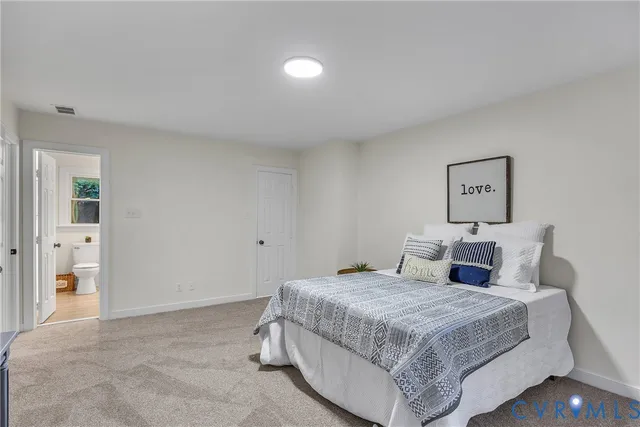 a bedroom with a bed and painting on the wall