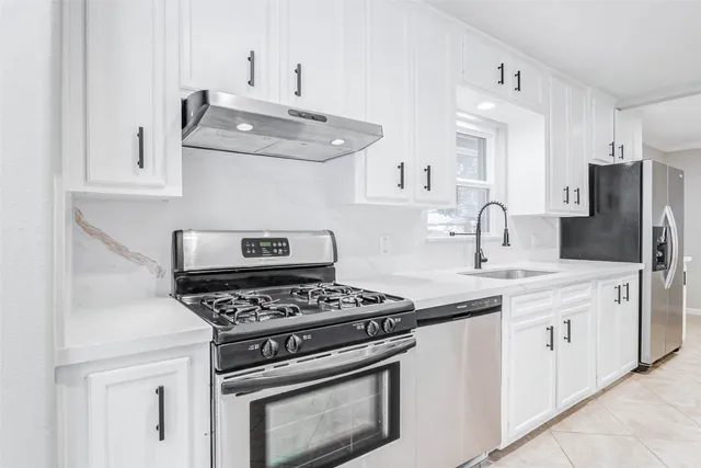 a kitchen with stainless steel appliances granite countertop a sink stove and refrigerator