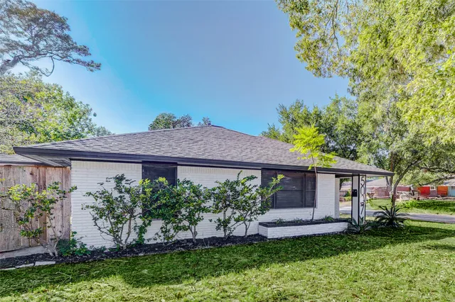 a front view of a house with a garden and plants
