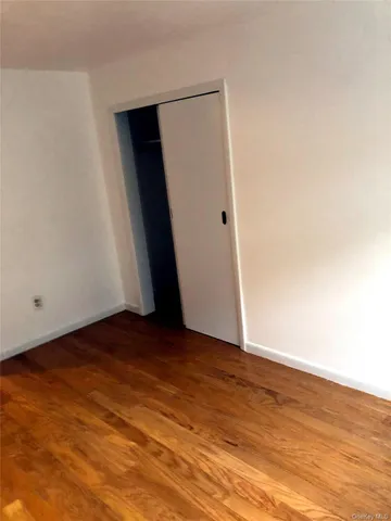 an empty room with wooden floor and closet