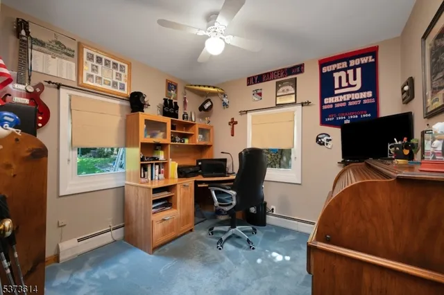 a view of a workspace with furniture and a window