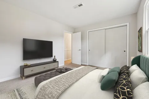 a bedroom with a bed and a flat screen tv