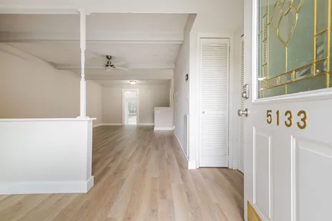 a view of a hallway with wooden floor