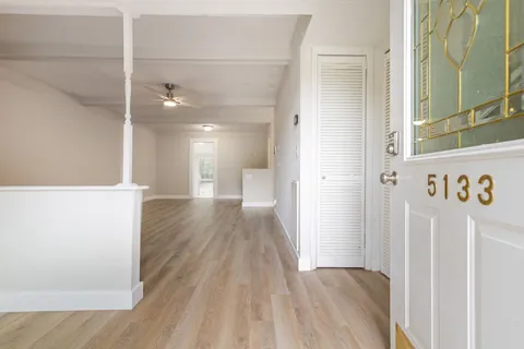 a view of a hallway with wooden floor
