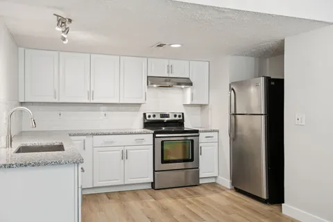 a kitchen with stainless steel appliances granite countertop a refrigerator stove and sink