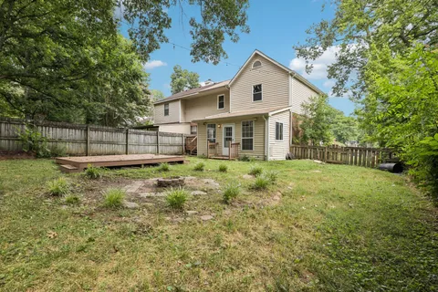 a view of a house with a yard and wooden fence