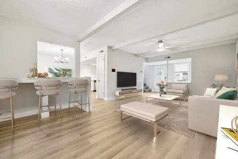 a living room with furniture a flat screen tv and a large window