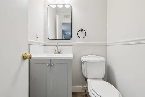 a bathroom with a toilet a sink and mirror