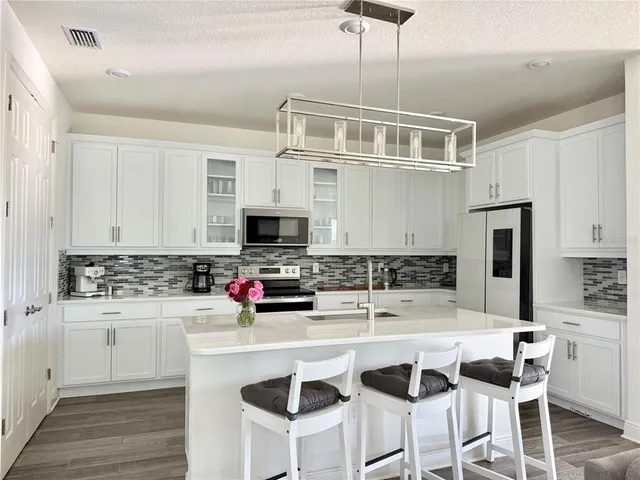 a kitchen with granite countertop a sink cabinets and stainless steel appliances