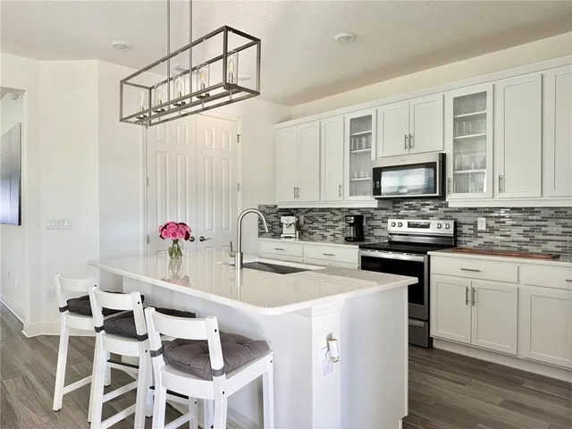 a kitchen with cabinets stainless steel appliances and a sink