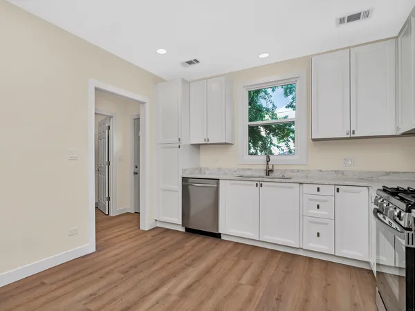 a kitchen with sink cabinets and wooden floor