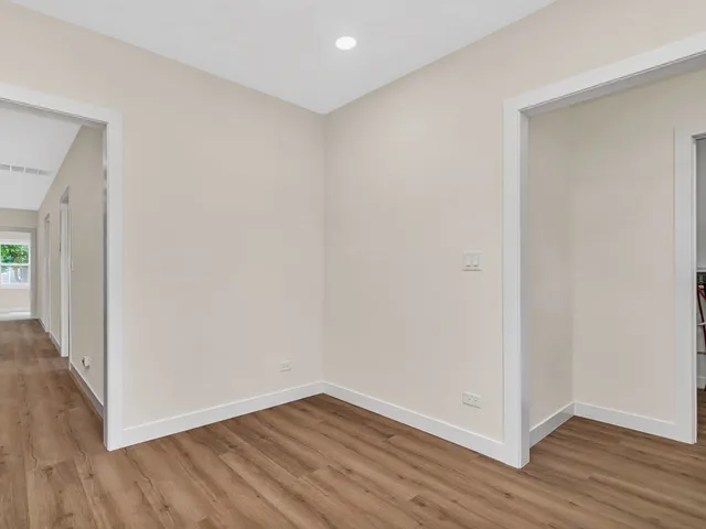 a view of an empty room with wooden floor