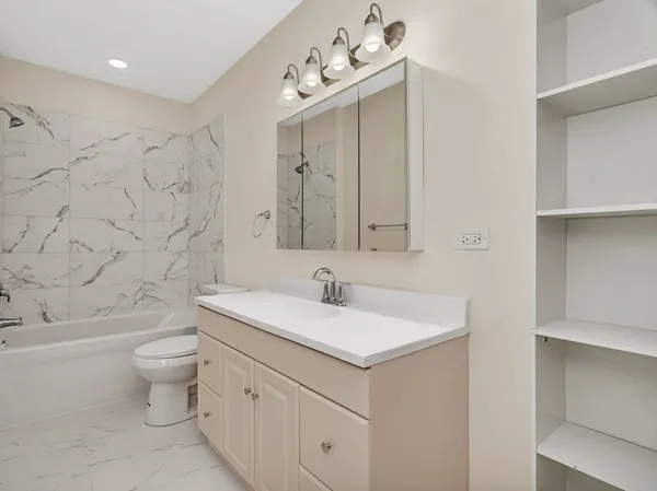 a bathroom with a sink vanity mirror and toilet