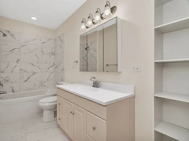 a bathroom with a sink vanity mirror and toilet