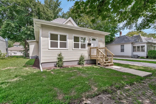 a view of a house with a yard and lawn chairs with a backyard