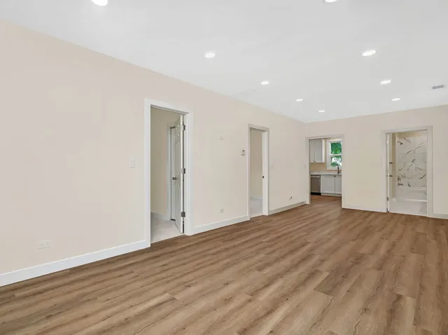 a view of empty room with wooden floor