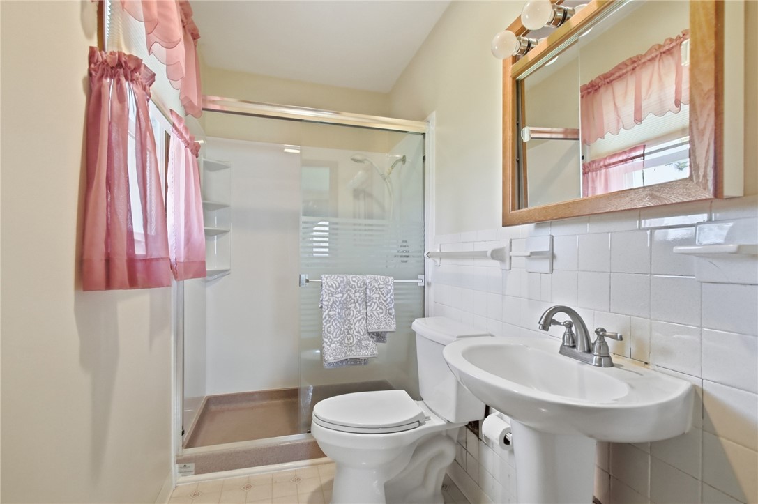 6718 Old Columbus Road South Vienna, OH 45369 - Photo 18 of 33 This bright bathroom features a pedestal sink and a walk-in shower.