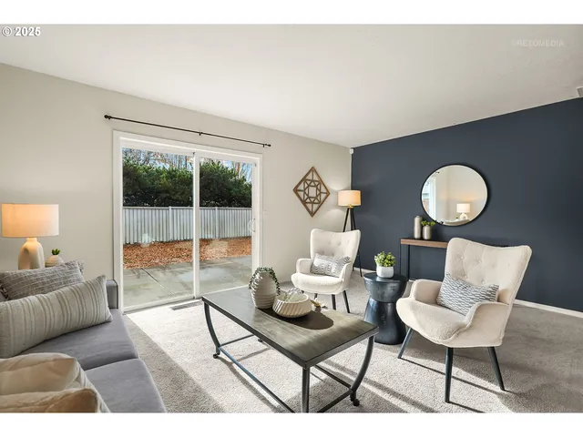 a living room with furniture a rug potted plant and a large window