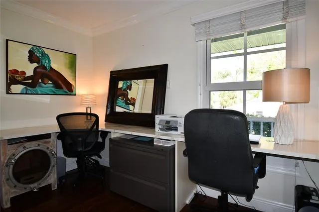 a bedroom with a bed painting on wall and windows