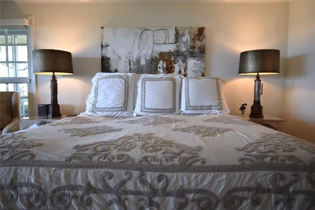 a bedroom with a bed a large window and flat screen tv